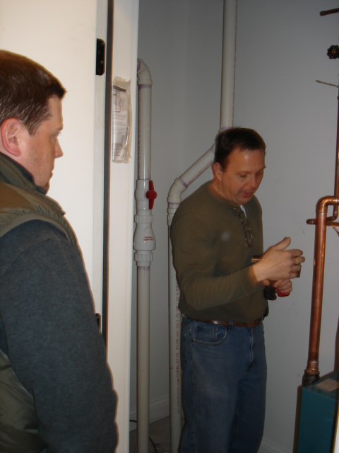 Home inspector Kevin Fulara explains the radiant heat boiler to buyer Brad Krauss